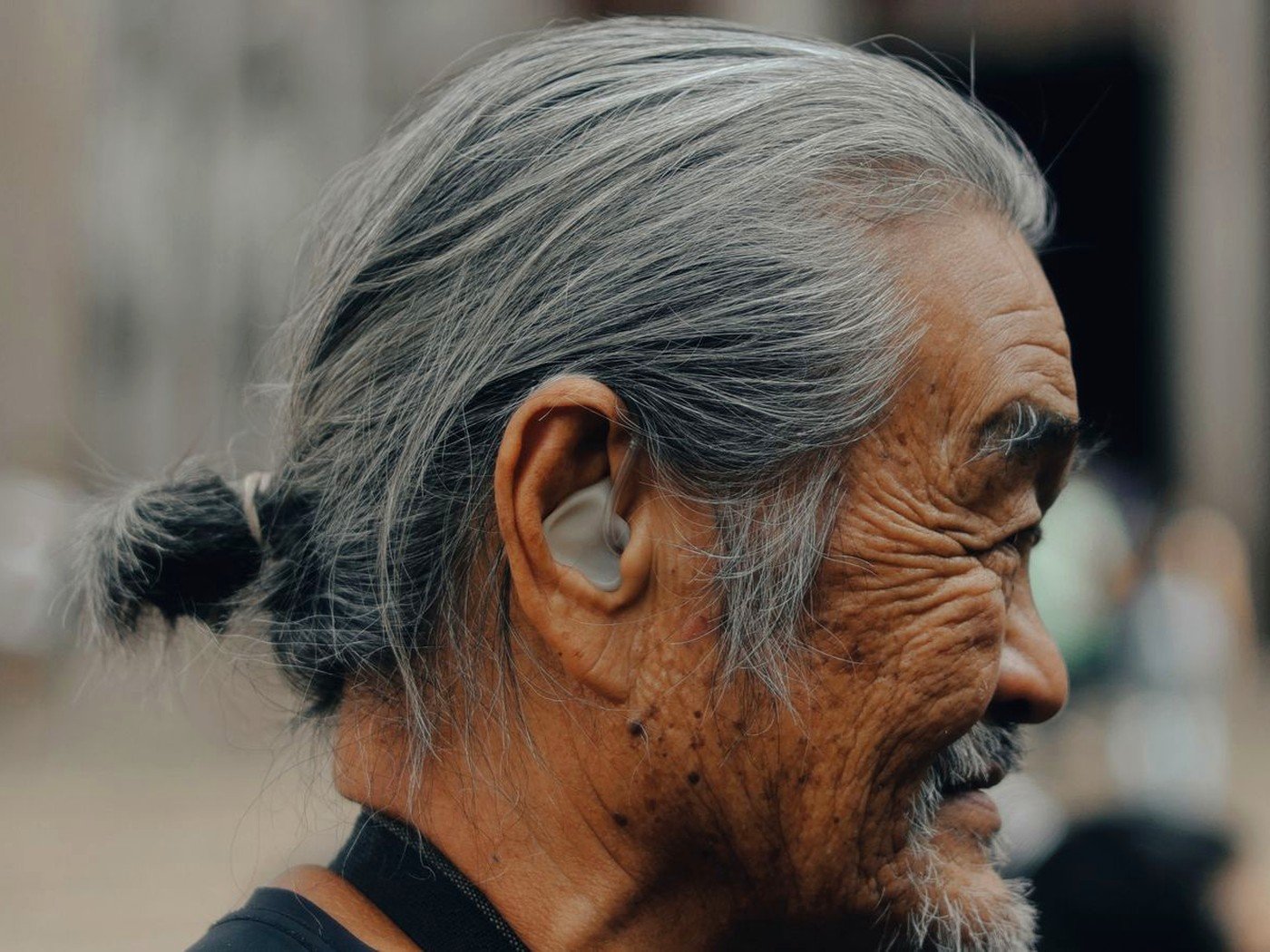 Elderly man wearing a hearing aid outdoors — hearing support for families in Kenya